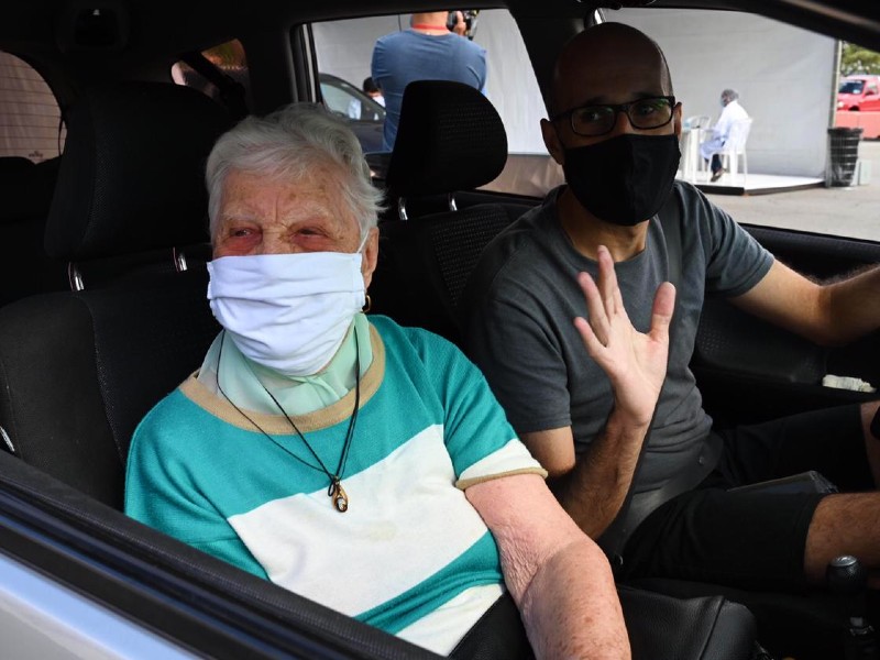 Antonia e o neto José estão dentro do carro no drive-thru do Anhembi depois que ela recebeu a vacina. Ambos usam máscara 